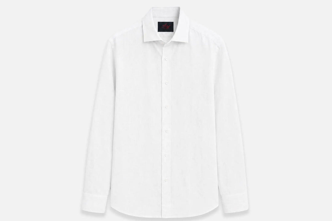 Chemise en lin blanche à plat sur fond clair, col ouvert et manches longues