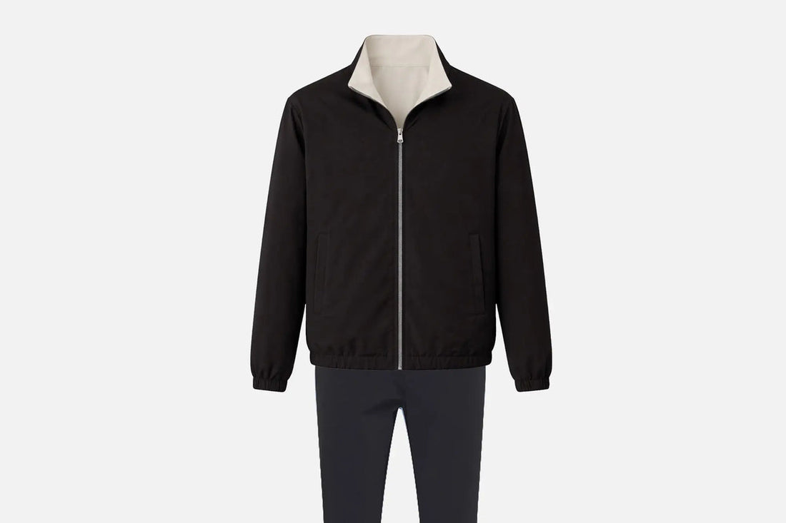 Ensemble réversible homme : veste noire à col crème et pantalon assorti, posés à plat sur fond clair.