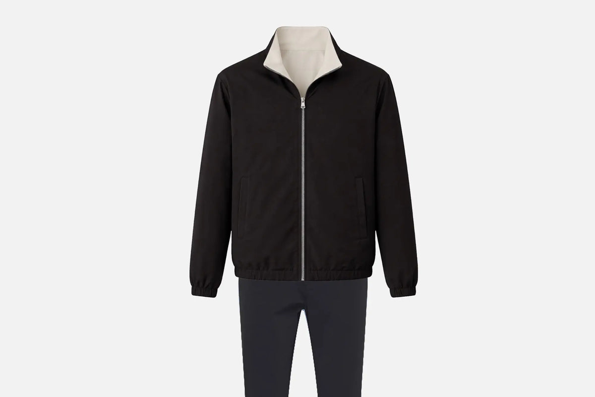 Ensemble réversible homme : veste noire à col crème et pantalon assorti, posés à plat sur fond clair.